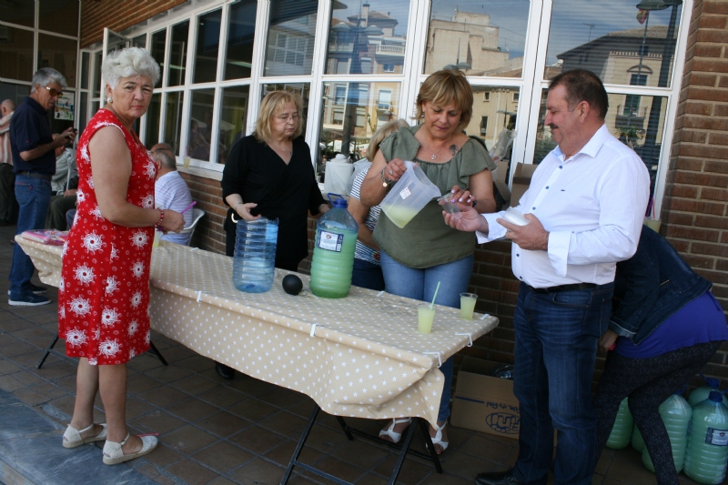 Socios y usuarios del Centro Municipal de Personas Mayores de la plaza Balsa Vieja disfrutan del reparto de agua limn con motivo de las fiestas