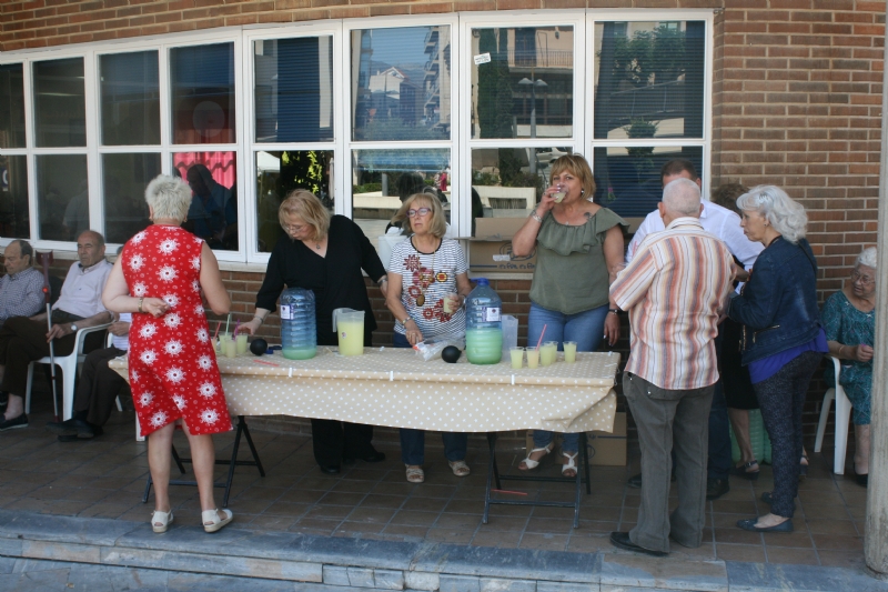 Socios y usuarios del Centro Municipal de Personas Mayores de la plaza Balsa Vieja disfrutan del reparto de agua limn con motivo de las fiestas