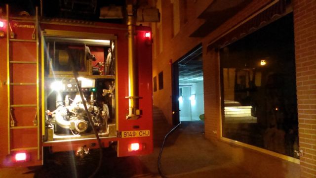 Agentes de la Polica Local de Totana y efectivos del Parque de Bomberos intervienen en el incendio de un vehculo en el interior de un garaje en la zona de San Roque